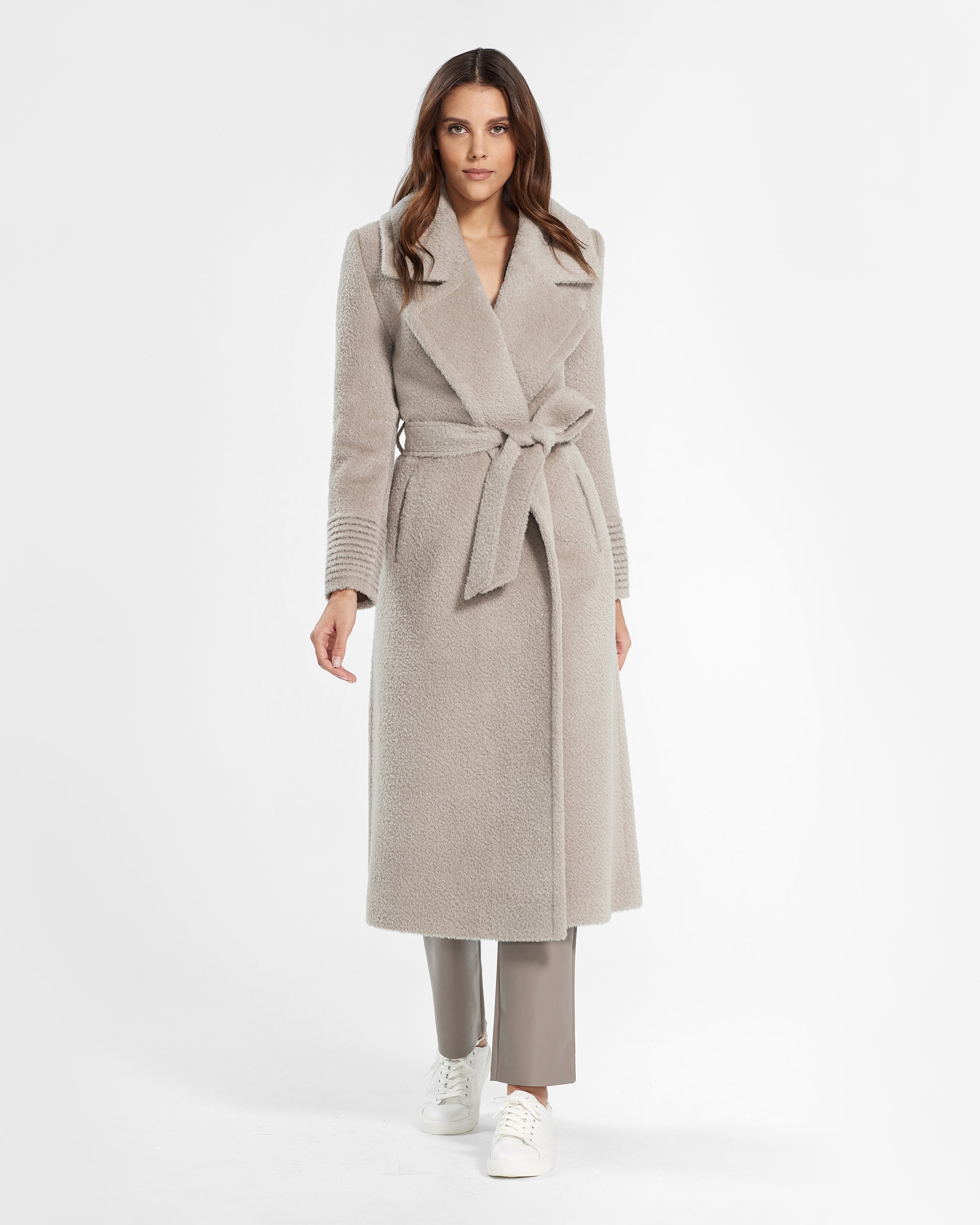 Front view of model wearing a Sentaler sand wrap coat made of bouclé alpaca wool, with a notched collar, worn belted.