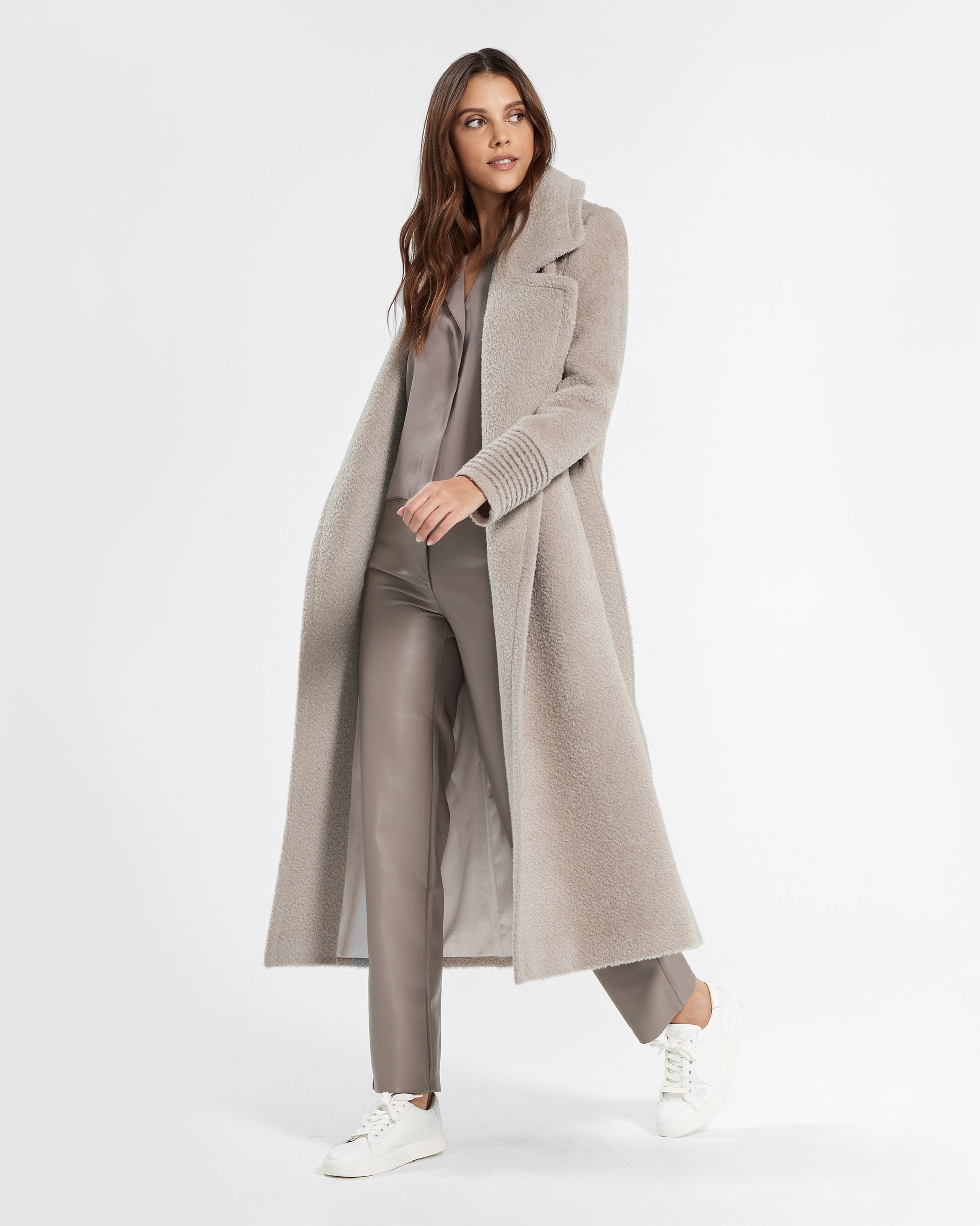 Side view of model wearing a Sentaler sand wrap coat made of bouclé alpaca wool, with a notched collar, worn open.