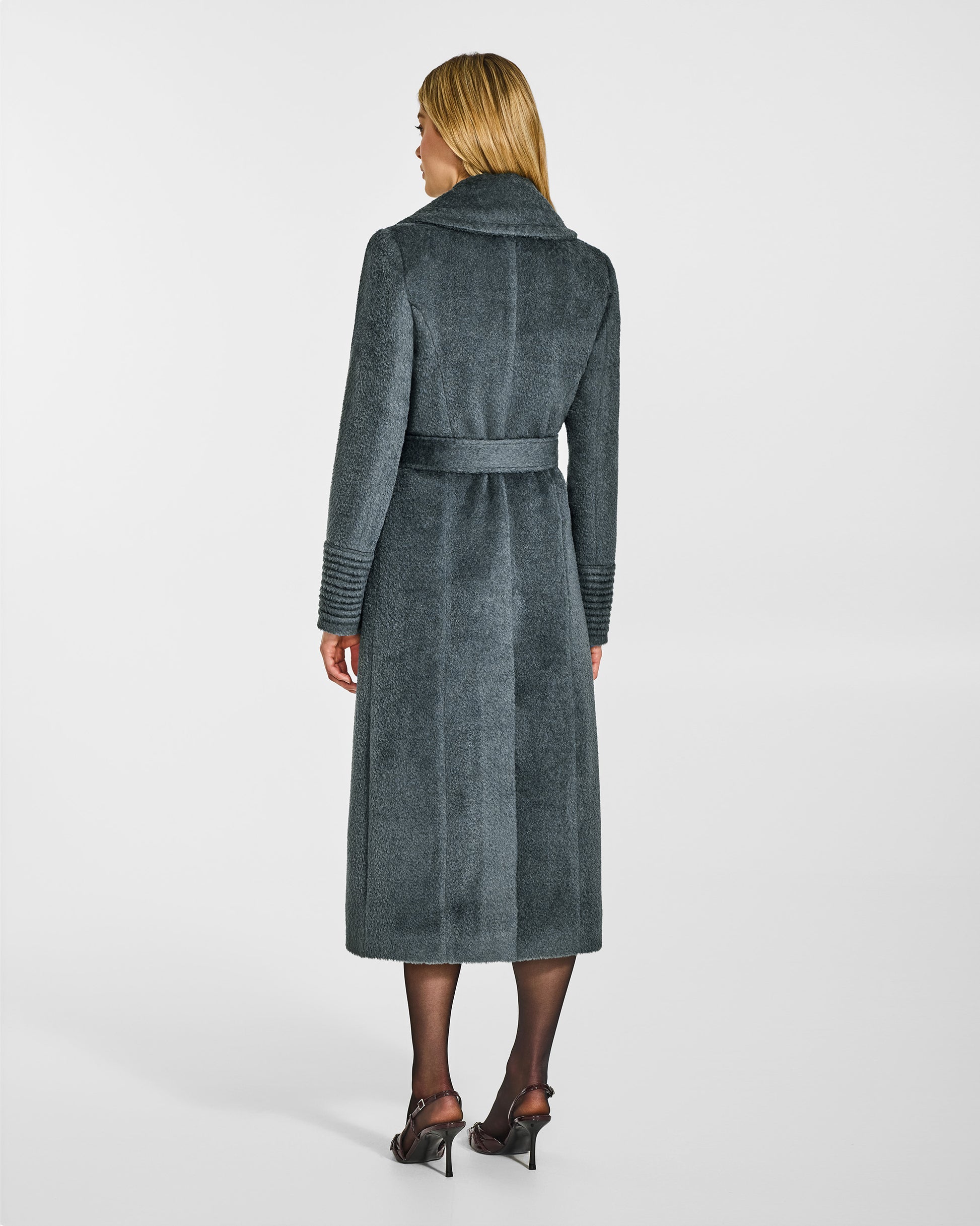 Back view of model wearing a Sentaler graphite grey wrap coat made of bouclé alpaca wool, with a notched collar, worn belted.