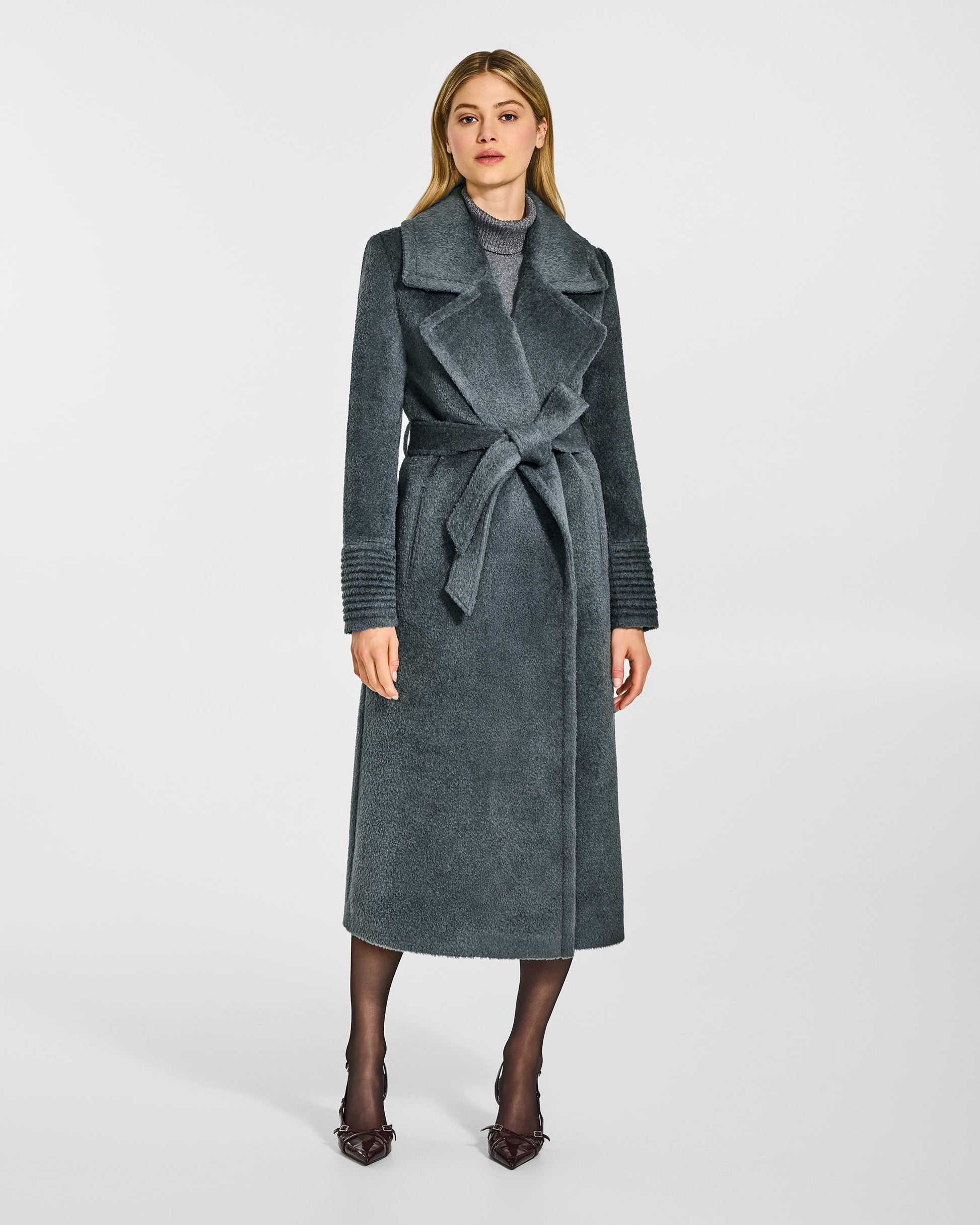 Front view of model wearing a Sentaler graphite grey wrap coat made of bouclé alpaca wool, with a notched collar, worn belted.