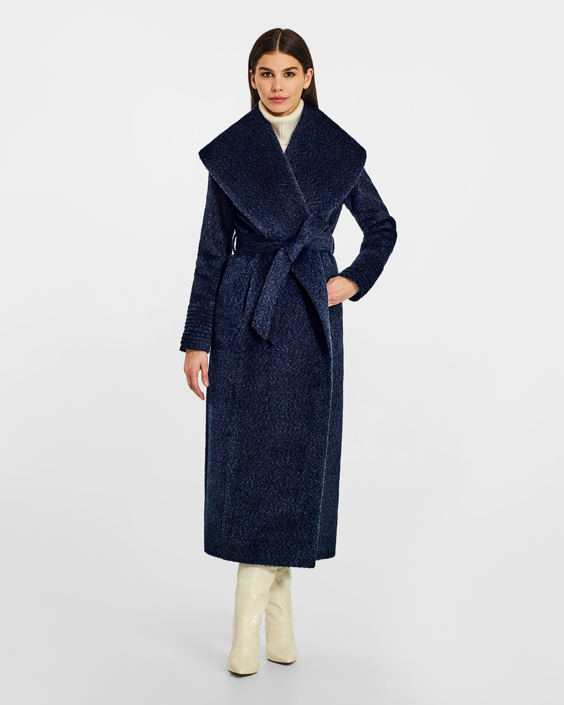 Front view of model wearing a Sentaler midnight blue maxi wrap coat made of bouclé alpaca wool, with a wide shawl collar, worn belted.