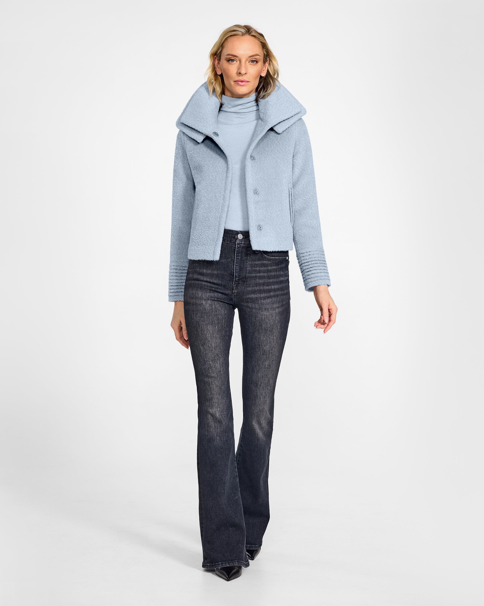 Front view of model wearing a Sentaler powder blue moto jacket made of bouclé alpaca wool, with a double collar, worn open.