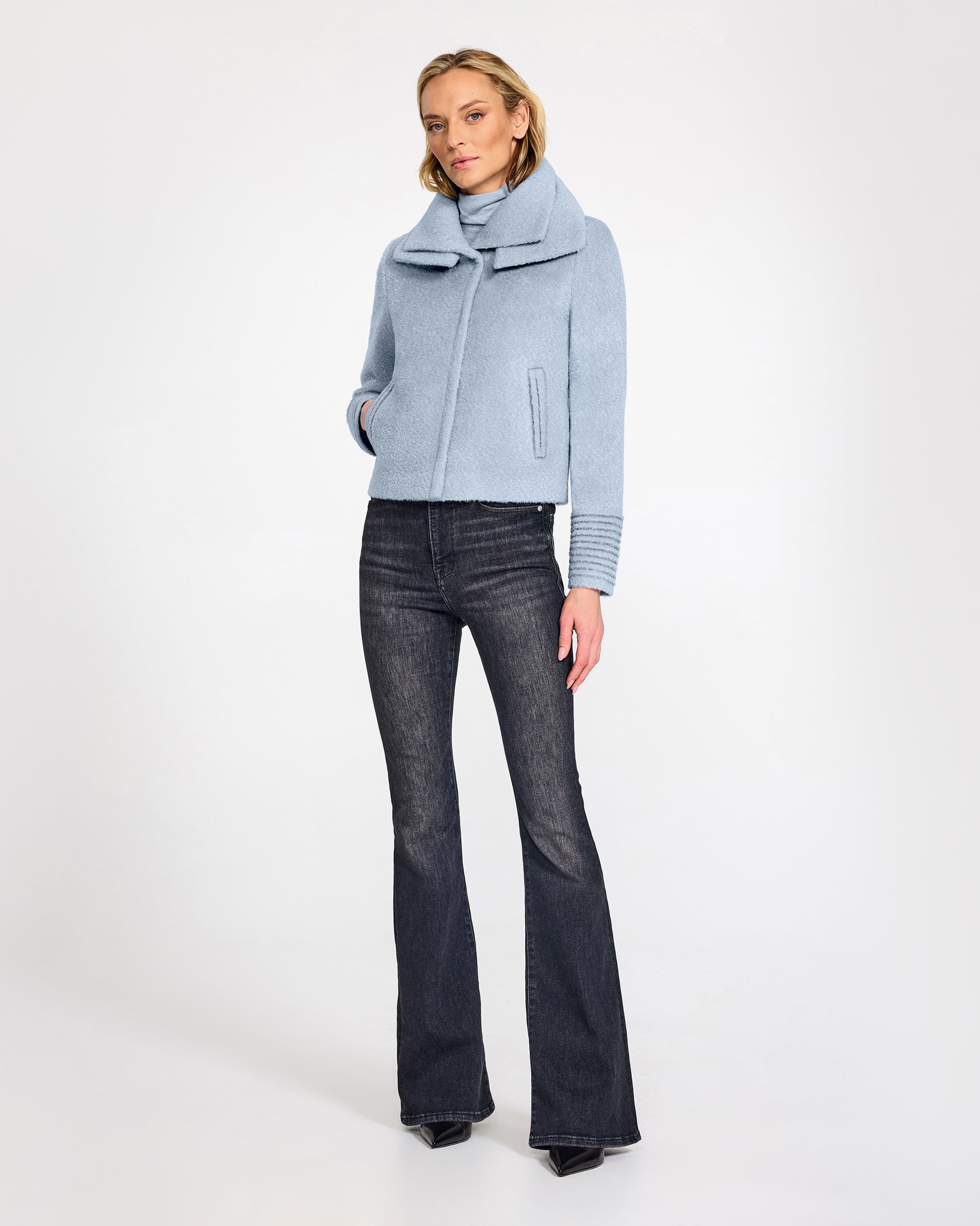 Front view of model wearing a Sentaler powder blue moto jacket made of bouclé alpaca wool, with a double collar, worn buttoned.