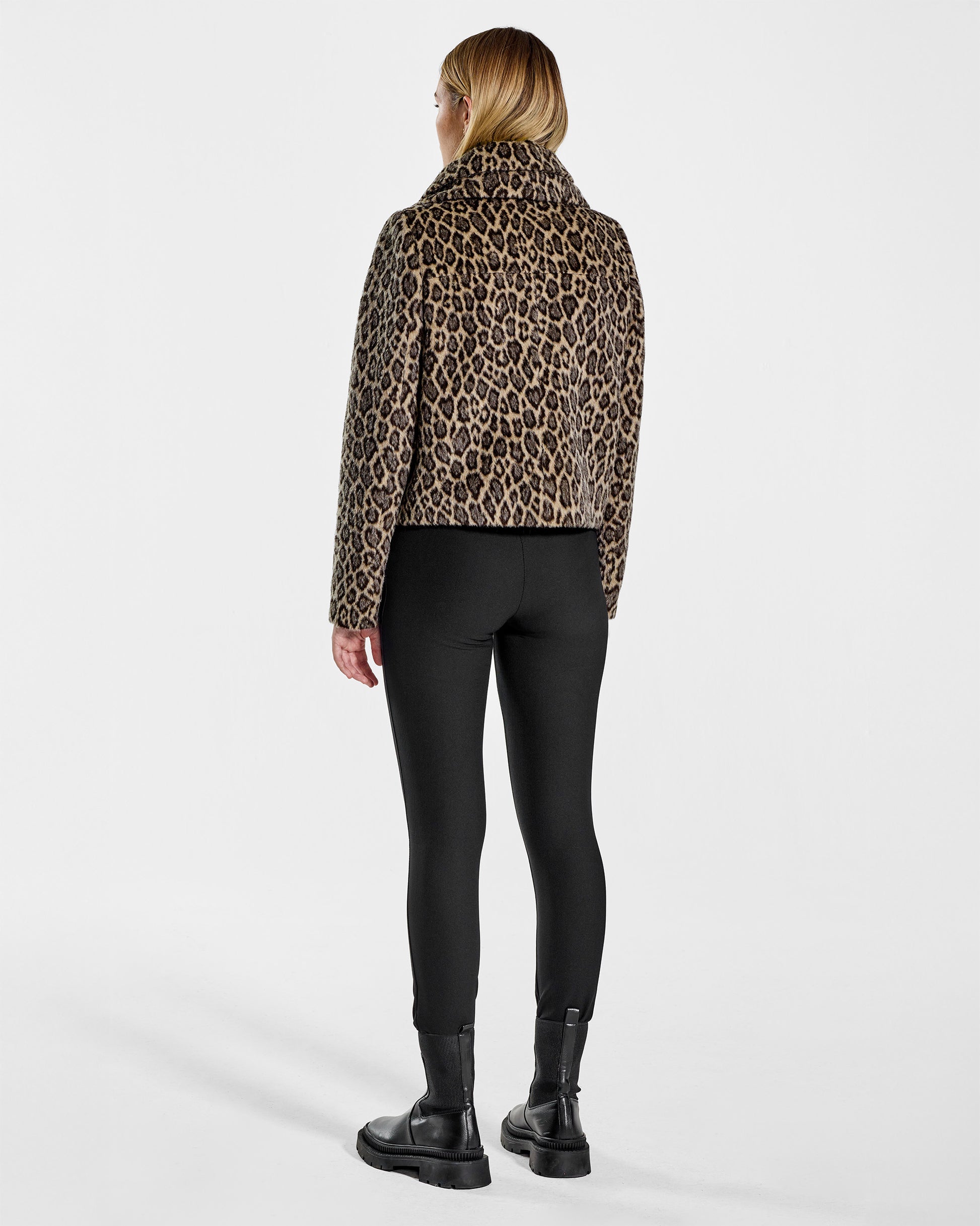 Back view of model wearing a Sentaler leopard moto jacket made of bouclé alpaca wool, with a double collar, worn buttoned.