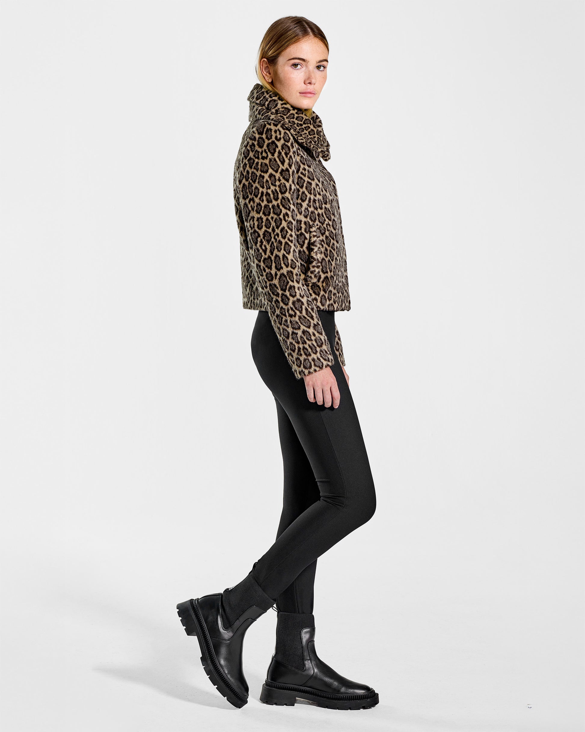 Side view of model wearing a Sentaler leopard moto jacket made of bouclé alpaca wool, with a double collar, worn buttoned.