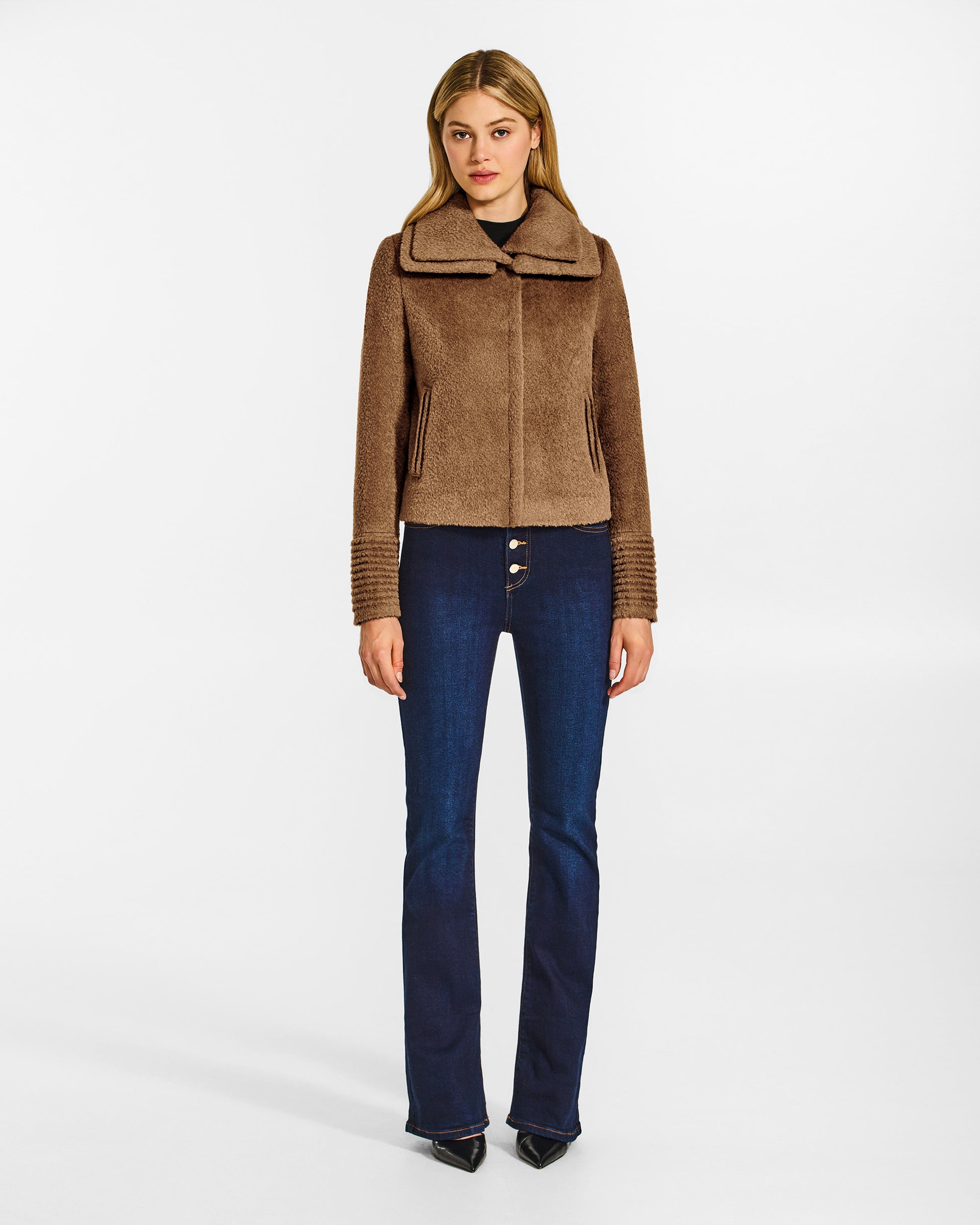 Front view of model wearing a Sentaler dark camel moto jacket made of bouclé alpaca wool, with a double collar, worn buttoned.