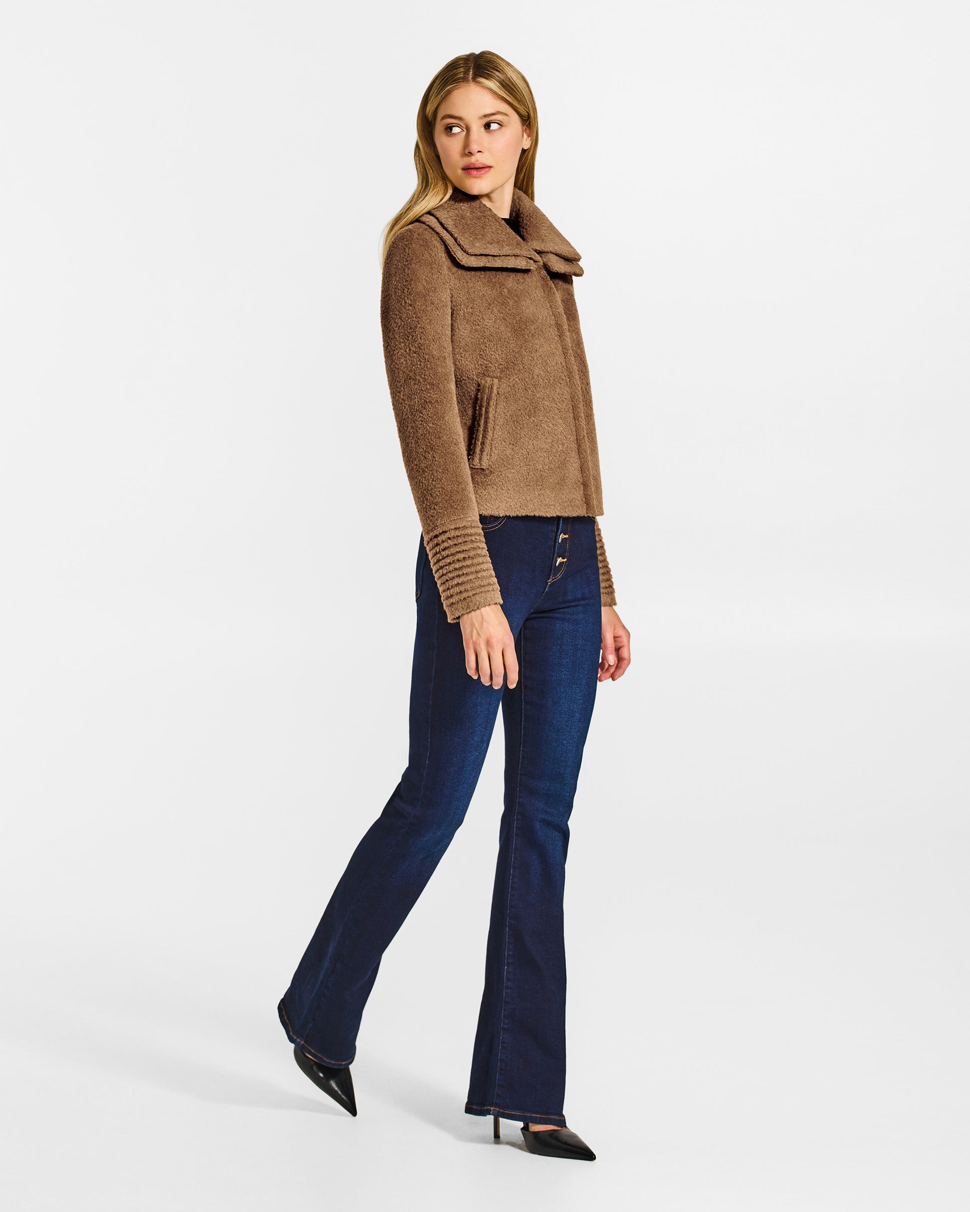 Side view of model wearing a Sentaler dark camel moto jacket made of bouclé alpaca wool, with a double collar, worn buttoned.