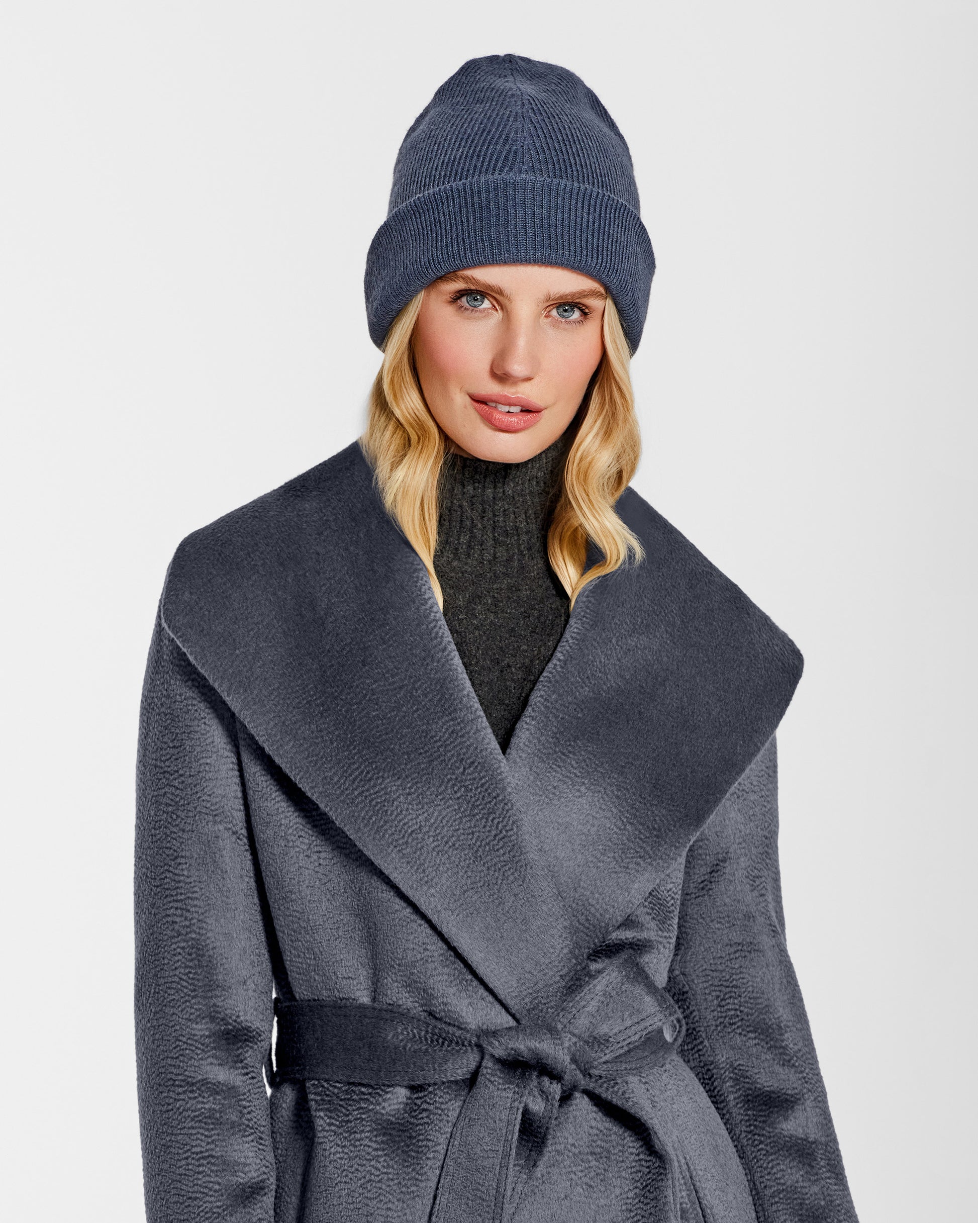 Front close up view of model wearing Sentaler's classic graphite beanie, made of baby alpaca yarn, paired with a graphite coat.