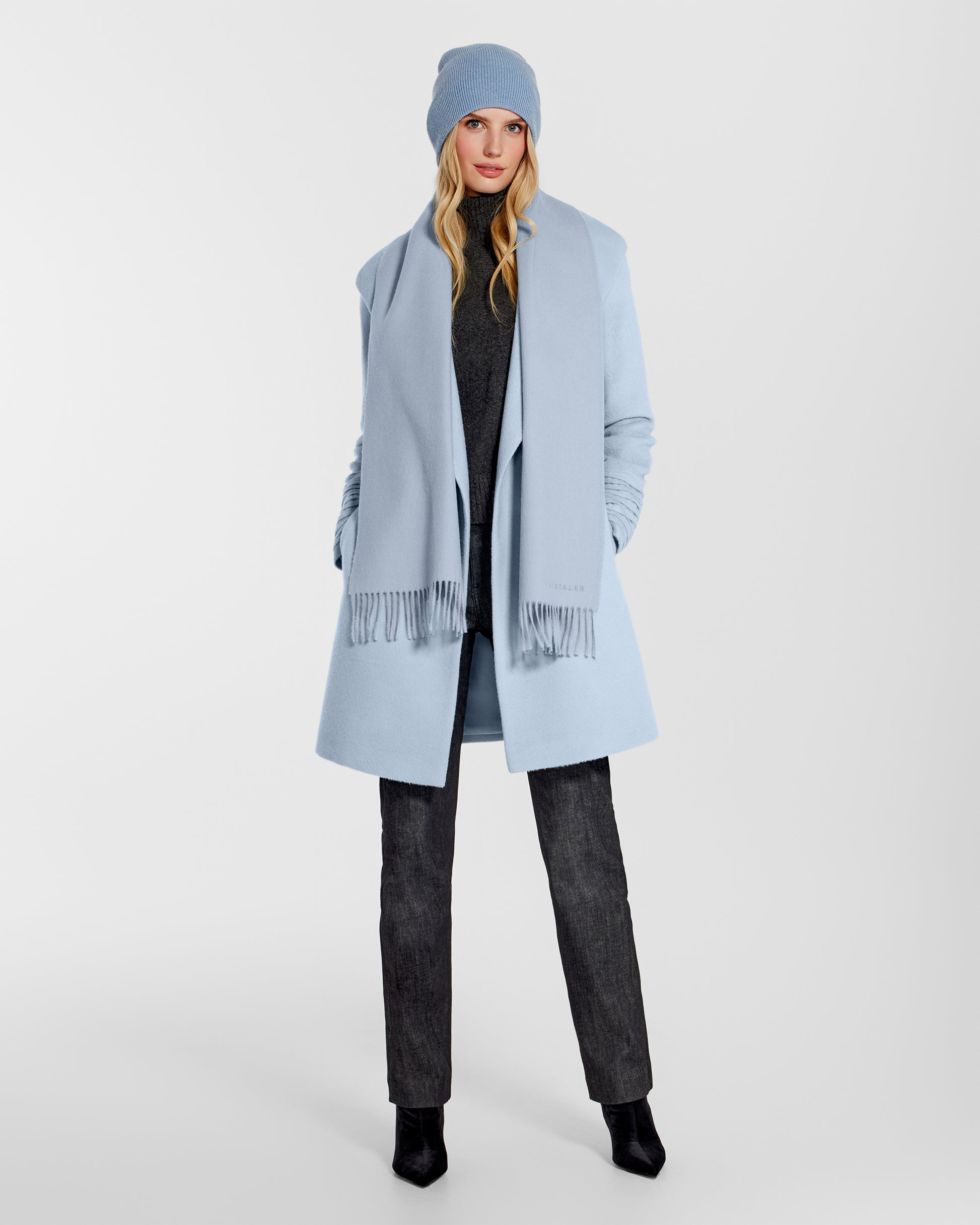 Front view of model wearing Sentaler's classic powder blue beanie, made of baby alpaca yarn, paired with a powder blue coat.