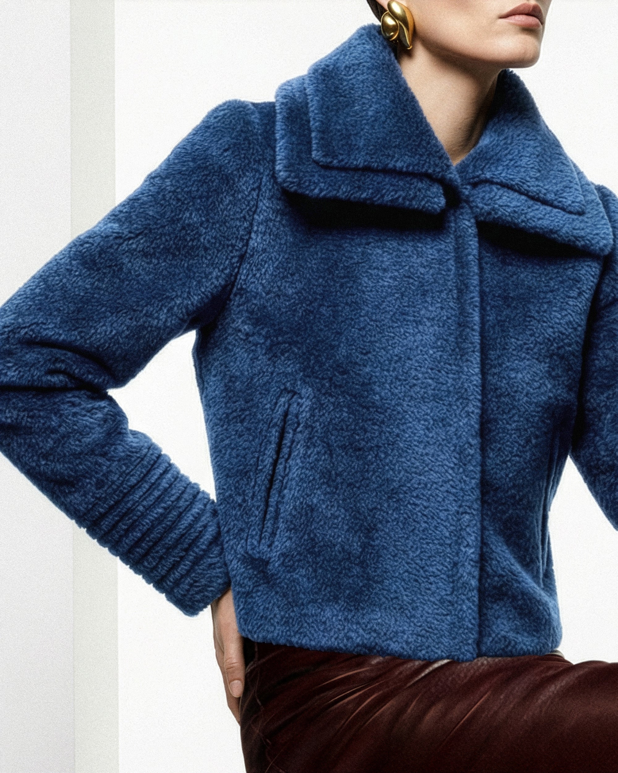 Front view of model wearing a Sentaler classic blue moto jacket made of bouclé alpaca wool, with a double collar, worn buttoned.