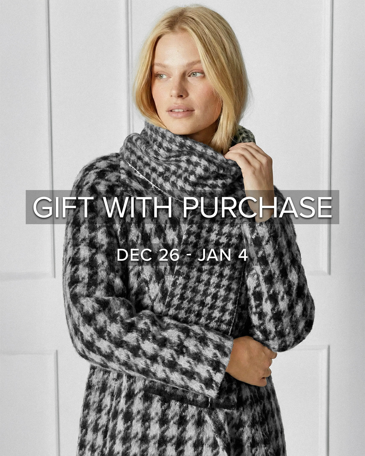 Front view of model wearing Sentaler's Black & White Houndstooth scarf, made of baby alpaca yarn. 