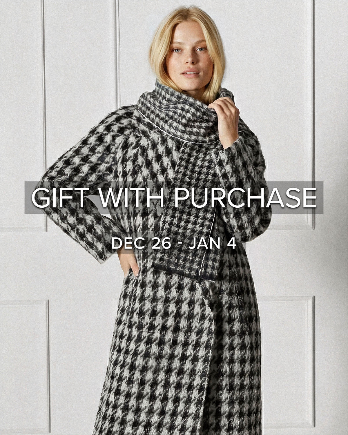 Front view of model wearing Sentaler's Black & White Houndstooth scarf, made of baby alpaca yarn. 