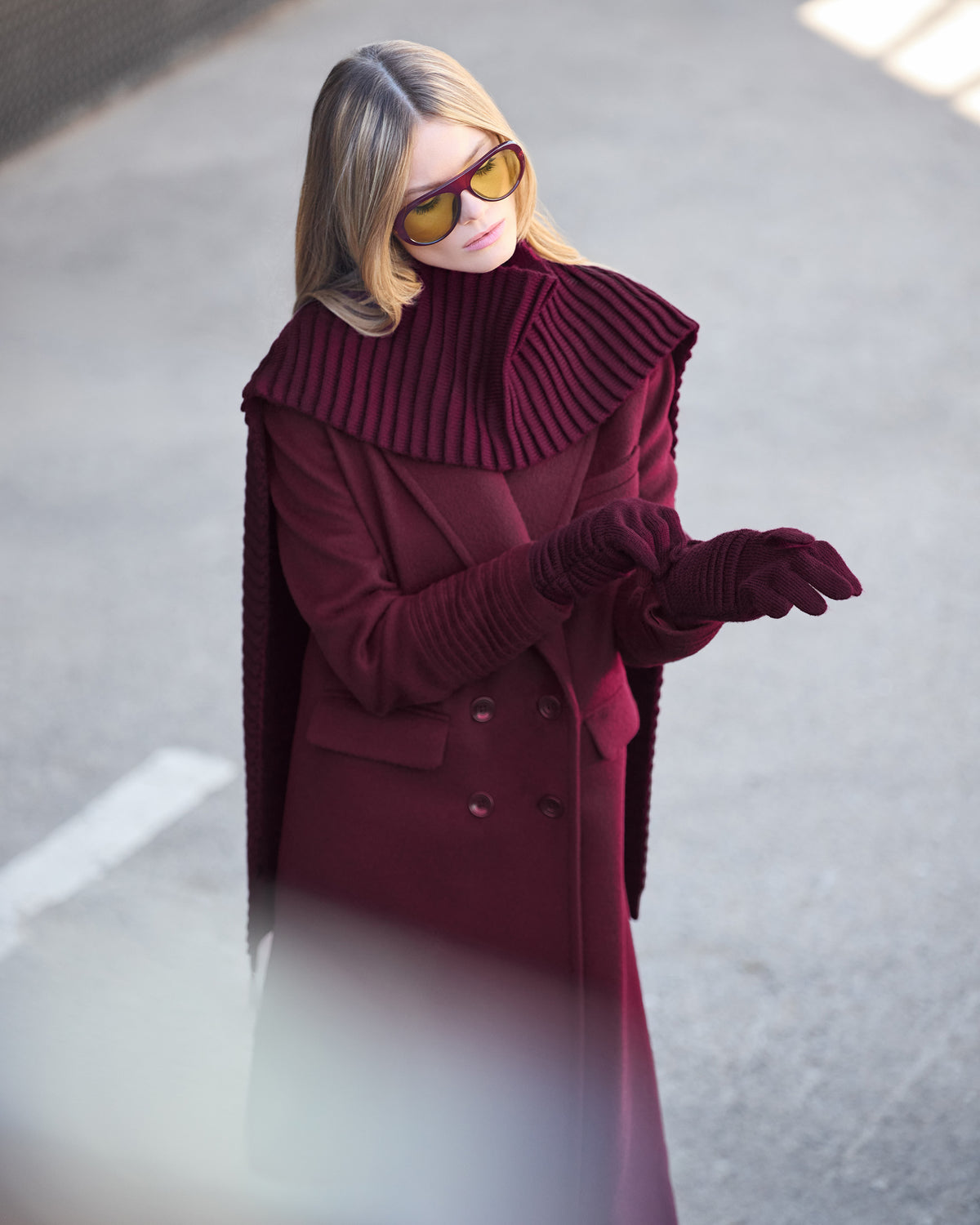 Front view of model wearing Sentaler's signature cherry lacquer ribbed hat, scarf, and gloves, paired with a matching cherry lacquer coat.
