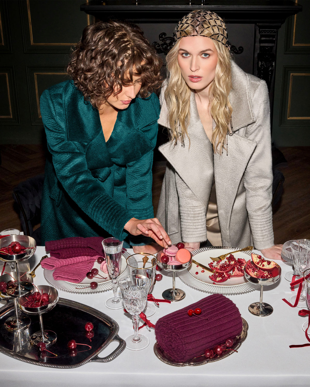 Front view of models wearing Sentaler sand and emerald maxi coats made of suri alpaca wool, with a notched collar, worn belted.