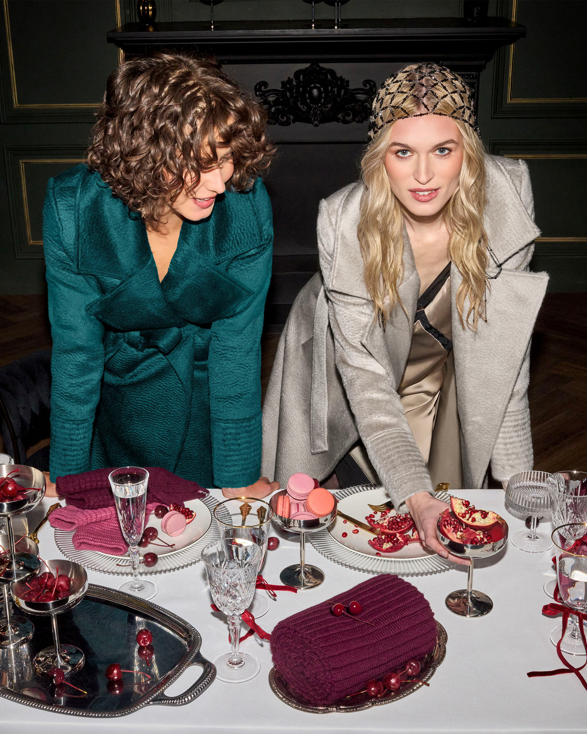 Front view of models wearing Sentaler sand and emerald maxi coats made of suri alpaca wool, with a notched collar, worn belted.