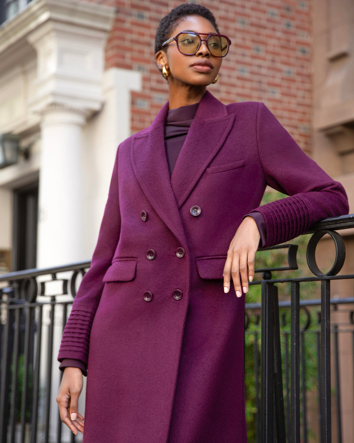 Front view of model wearing a Sentaler cherry lacquer double breasted maxi coat made of baby alpaca wool, with a peak collar, worn buttoned.
