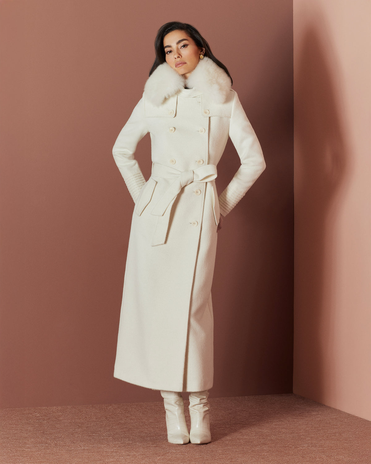 Front view of model in Sentaler maxi ivory trench coat made of baby alpaca wool with shearling collar, buttoned & belted.