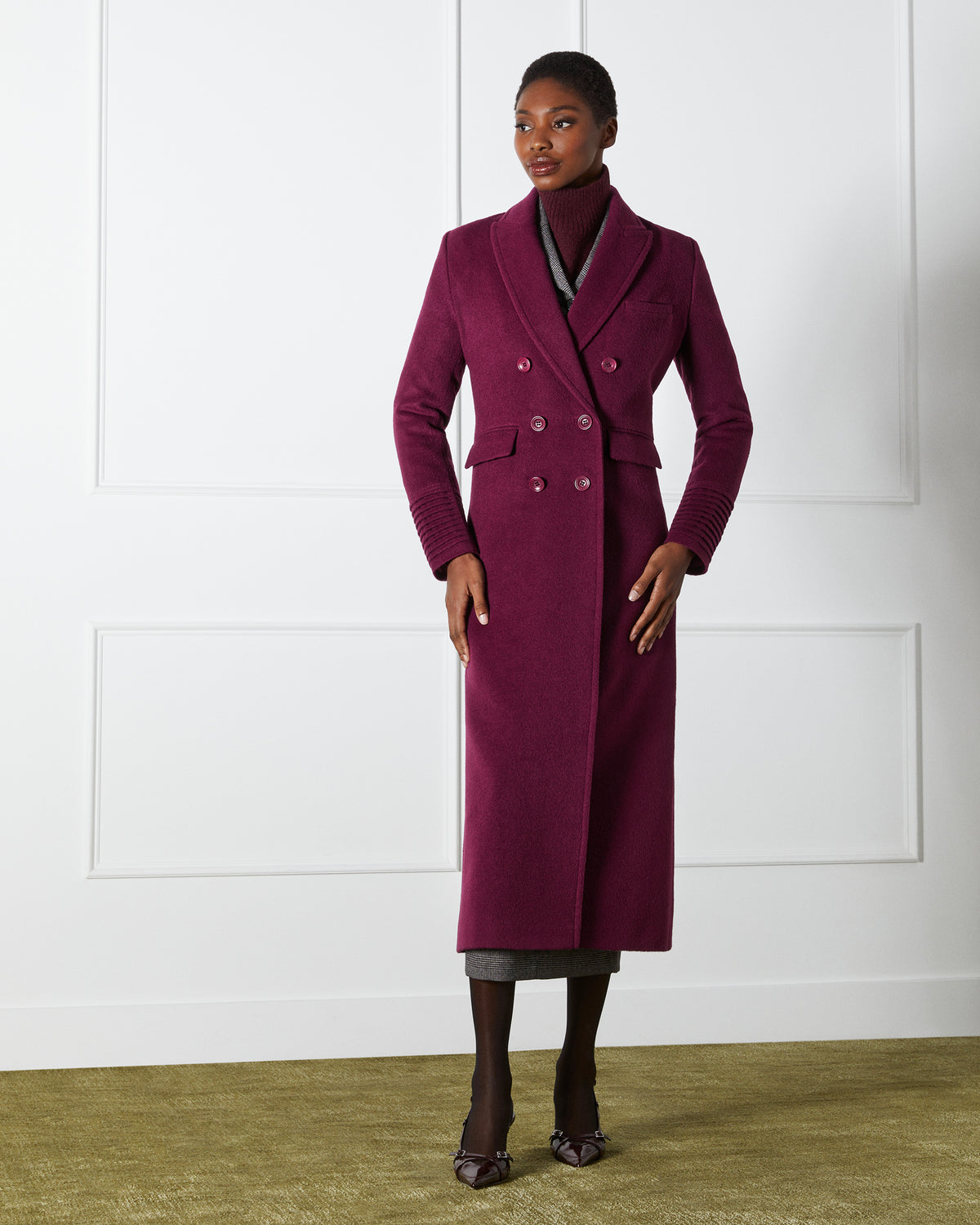 Front view of model wearing a Sentaler cherry lacquer double breasted maxi coat made of baby alpaca wool, with a peak collar, worn buttoned.