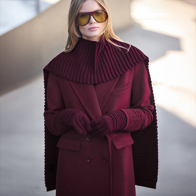 Front view of model wearing a Sentaler cherry lacquer double breasted maxi coat made of baby alpaca wool, with a peak collar, worn buttoned.