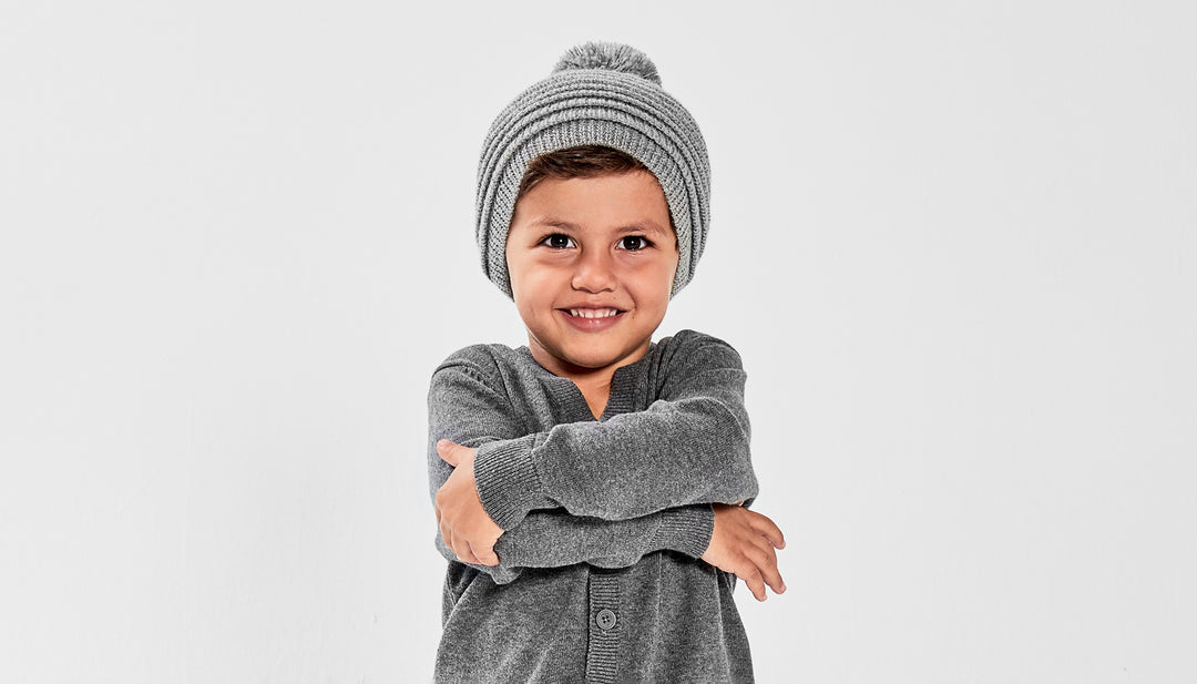 Sentaler Kids (1-5 Years) Ribbed Hat with Oversized Knit Pompon featured in Baby Alpaca and available in Grey. Seen from front on model above the waist.
