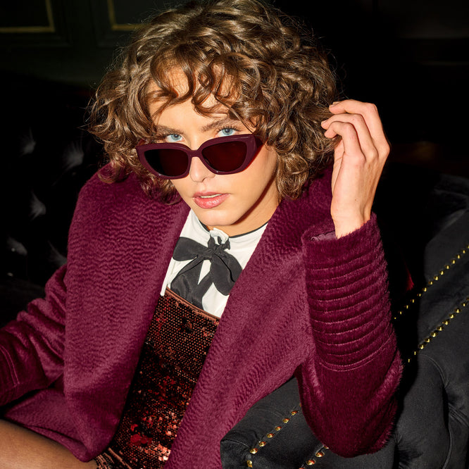 Front view of model wearing a Sentaler long cherry lacquer wrap coat made of suri alpaca wool, with a shawl collar, worn open.