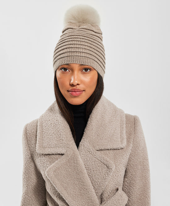 Sentaler Adult Ribbed Hat With Oversized Fur Pompon featured in Baby Alpaca and available in Light Taupe Neutral. Seen from front on female model close up.