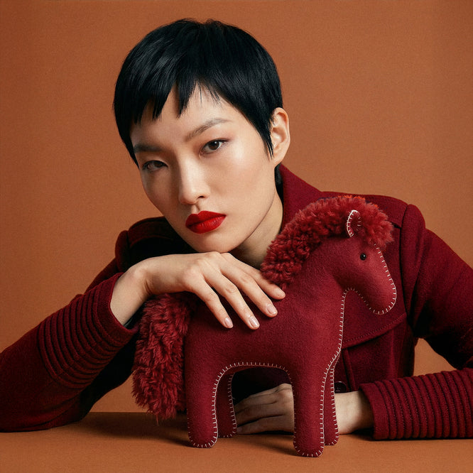 Front view of model wearing a Sentaler garnet red long wrap coat made of baby alpaca wool, with a wide collar, worn belted.