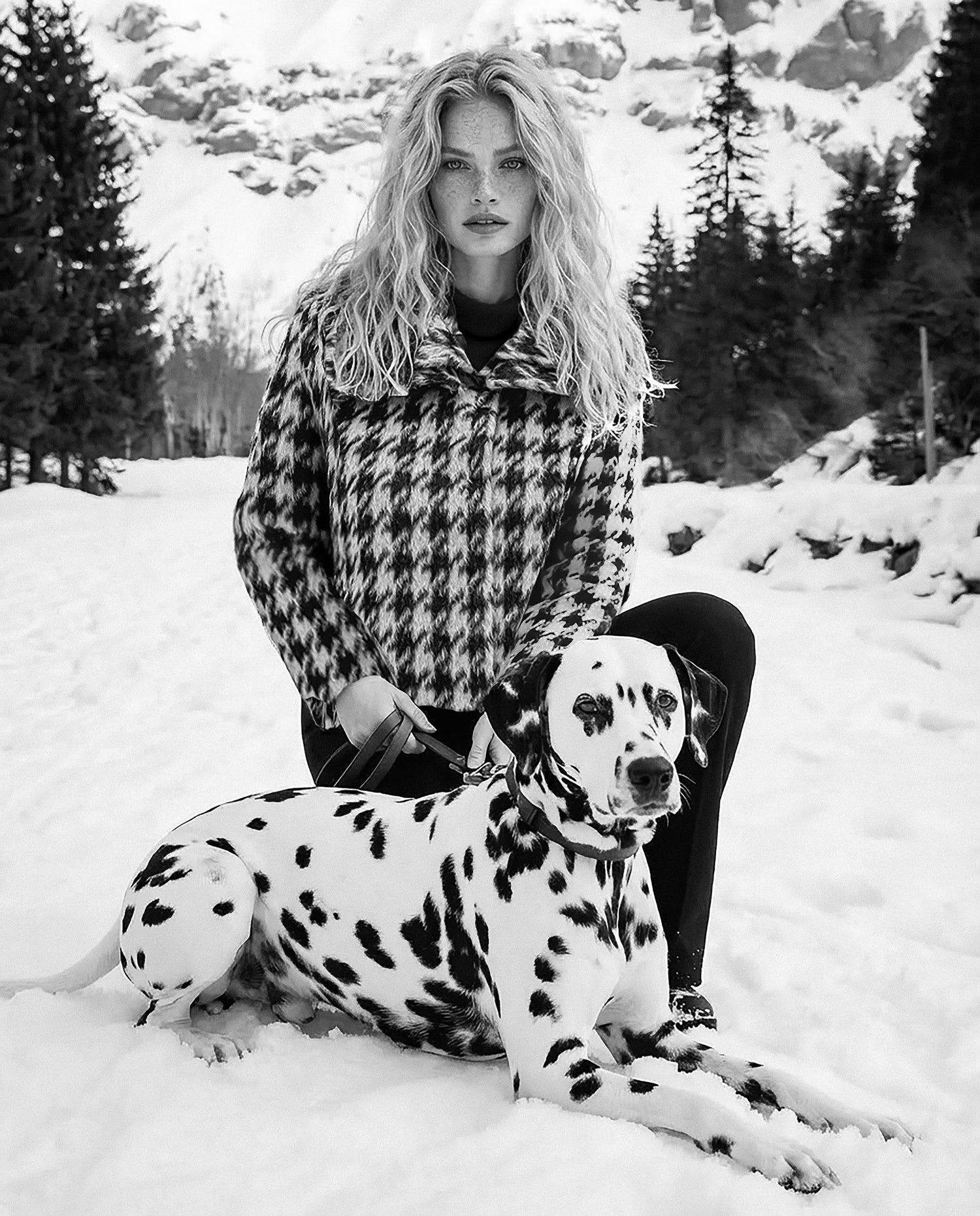 Front view of model wearing a Sentaler black & white houndstooth moto jacket made of bouclé alpaca wool, with a double collar, worn buttoned.