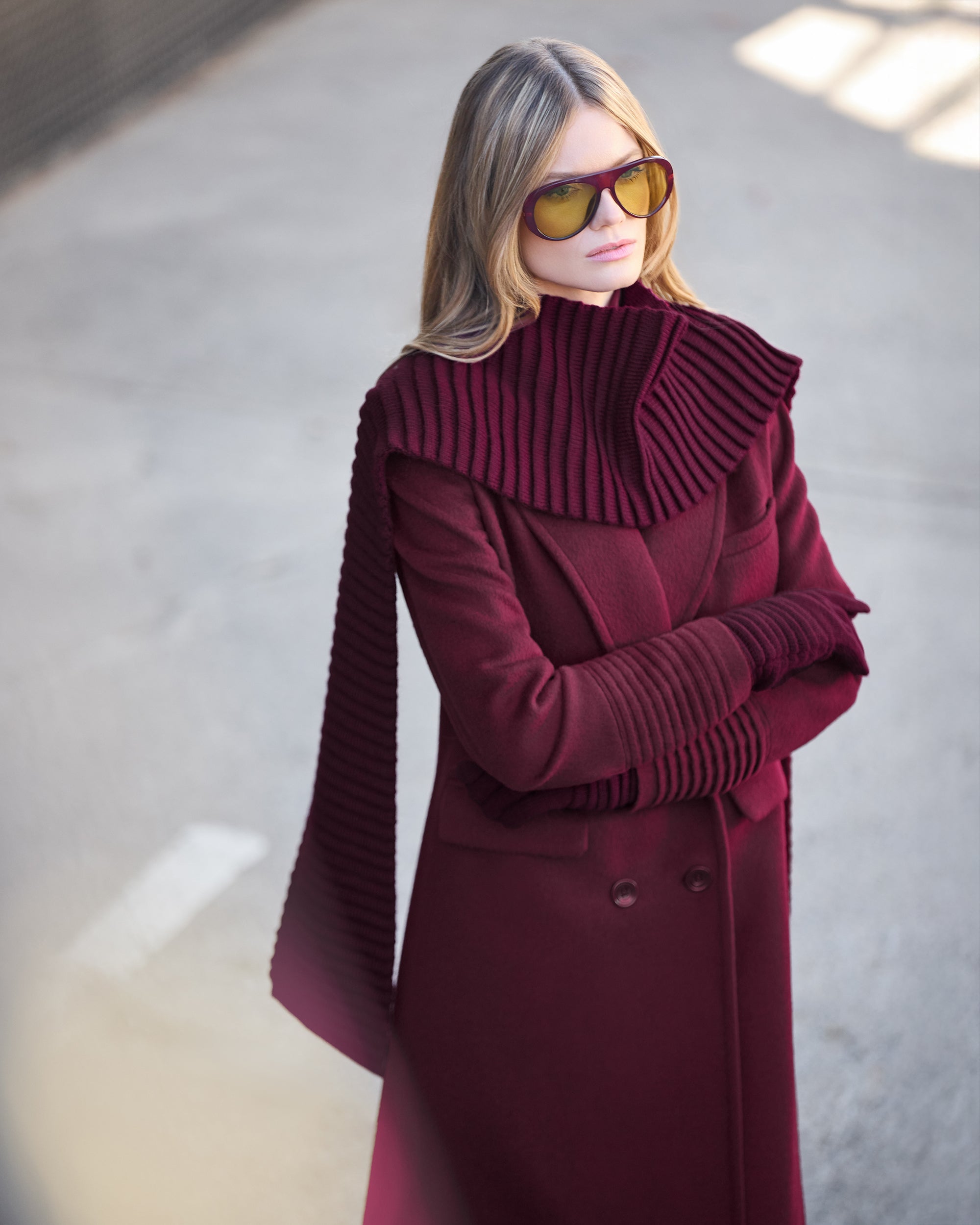 Front view of model wearing a Sentaler cherry lacquer double breasted maxi coat made of baby alpaca wool, with a peak collar, worn buttoned.