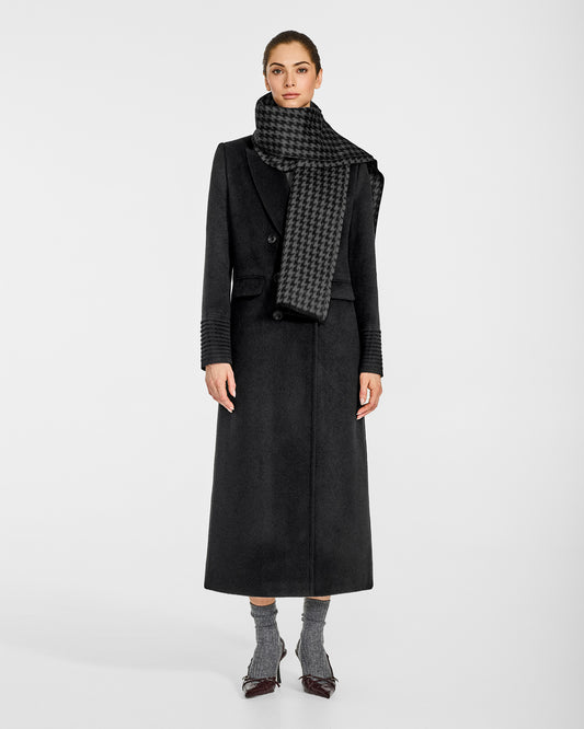 Front view of model wearing Sentaler's Black & Graphite Houndstooth scarf, made of baby alpaca yarn. 