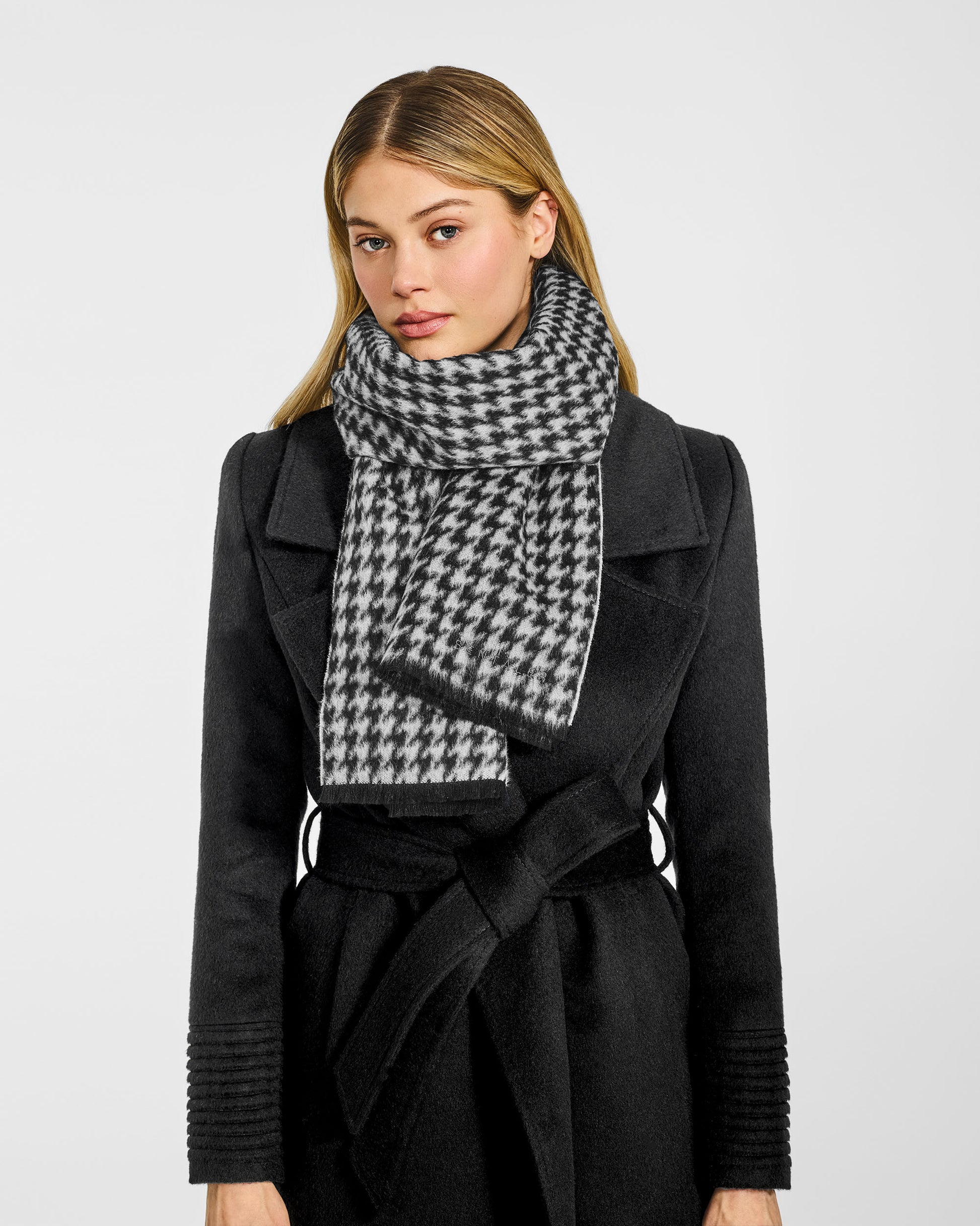 Front view of model wearing Sentaler's Black & White Houndstooth scarf, made of baby alpaca yarn. 