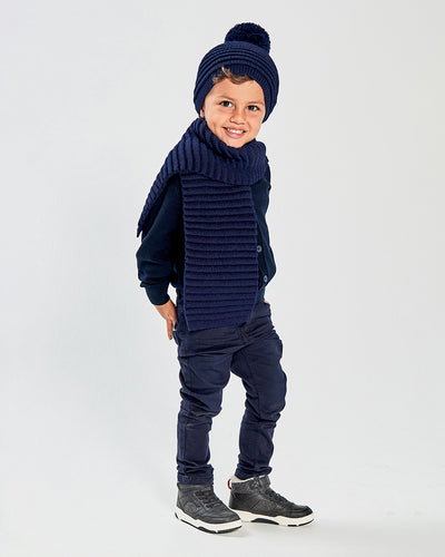 Sentaler Kids Ribbed Navy Hat with Knit Pompon (4-5 Years) and Kids Ribbed Navy Scarf (4-5 Years) in Baby Alpaca yarn. Seen from side on boy model.