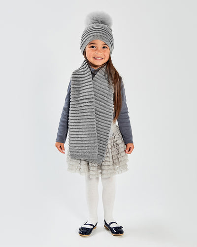 Sentaler Kids Ribbed Grey Scarf (4-5 Years) and Kids Ribbed Grey Hat with Fur Pompon (4-5 Years) in Baby Alpaca yarn. Seen from front on girl model.