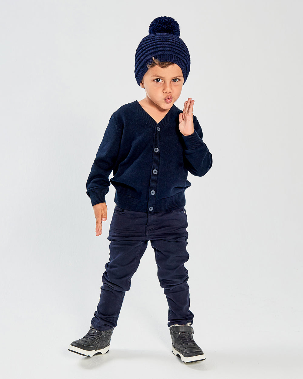 Sentaler Kids Ribbed Navy Hat with Knit Pompon (4-5 Years) in Baby Alpaca yarn. Seen from front on boy model.