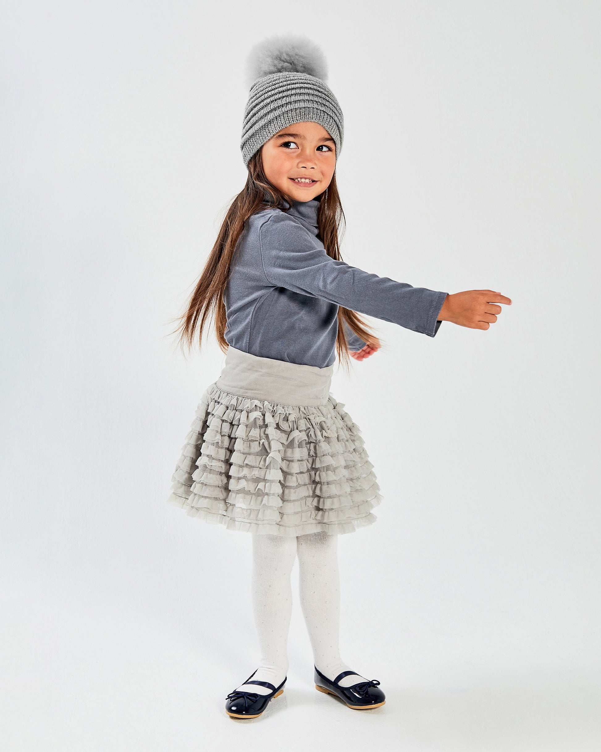 Sentaler Kids Ribbed Grey Scarf & Pompon Hat (1-5 Years) in Baby Alpaca yarn. Seen from front on girl model.