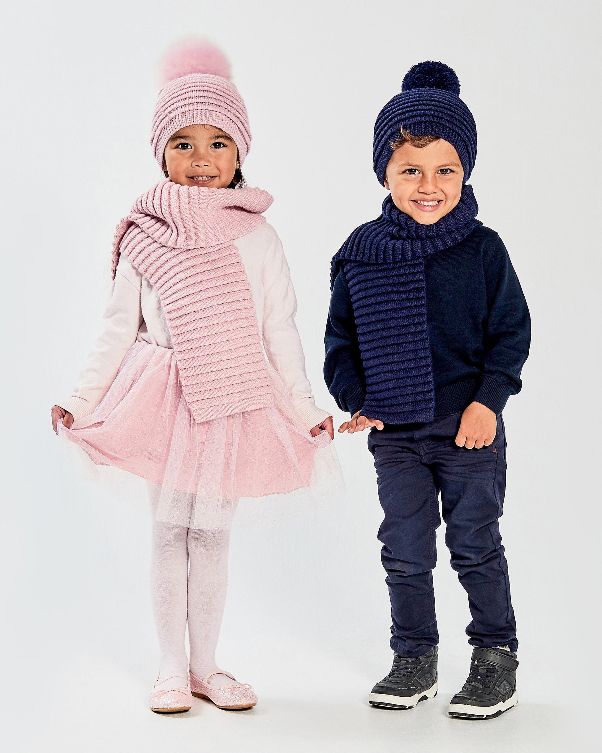 Sentaler Kids Ribbed Pink Scarf & Pompon Hat (1-5 Years) in Baby Alpaca yarn. Seen from front on girl model.