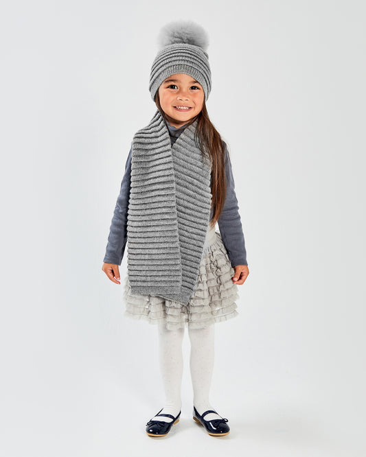 Sentaler Kids Ribbed Grey Hat with Fur Pompon (1-5 Years) and Kids Ribbed Grey Scarf (1-5 Years) in Baby Alpaca yarn. Seen from front on girl model.