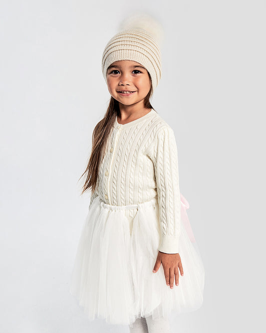 Sentaler Kids Ribbed Ivory Hat with Fur Pompon (4-5 Years) in Baby Alpaca yarn. Seen from front on girl model.