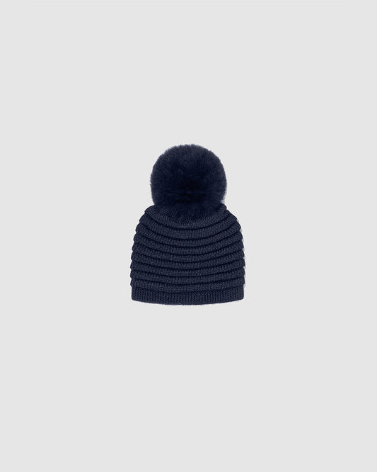 Sentaler Kids Ribbed Navy Hat with Fur Pompon (4-5 Years) in Baby Alpaca yarn. Seen as off figure.