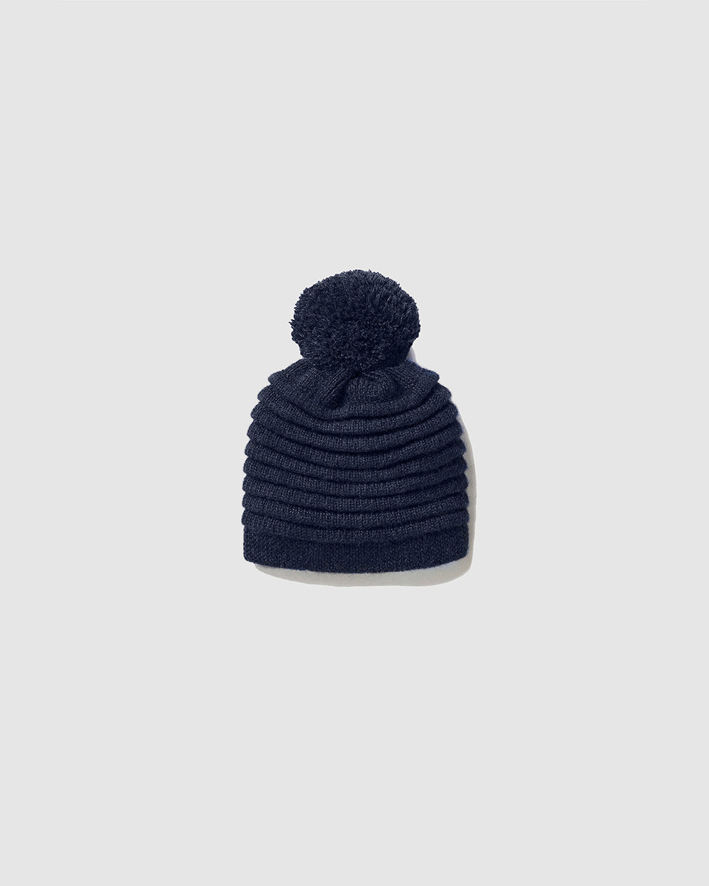 Sentaler Kids Ribbed Navy Hat with Knit Pompon (4-5 Years) in Baby Alpaca yarn. Seen as off figure.