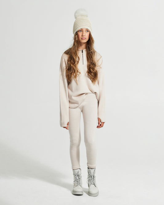 Sentaler Kids Ribbed Ivory Hat with Fur Pompon (6-14 Years) in Baby Alpaca yarn. Seen from front on girl model.