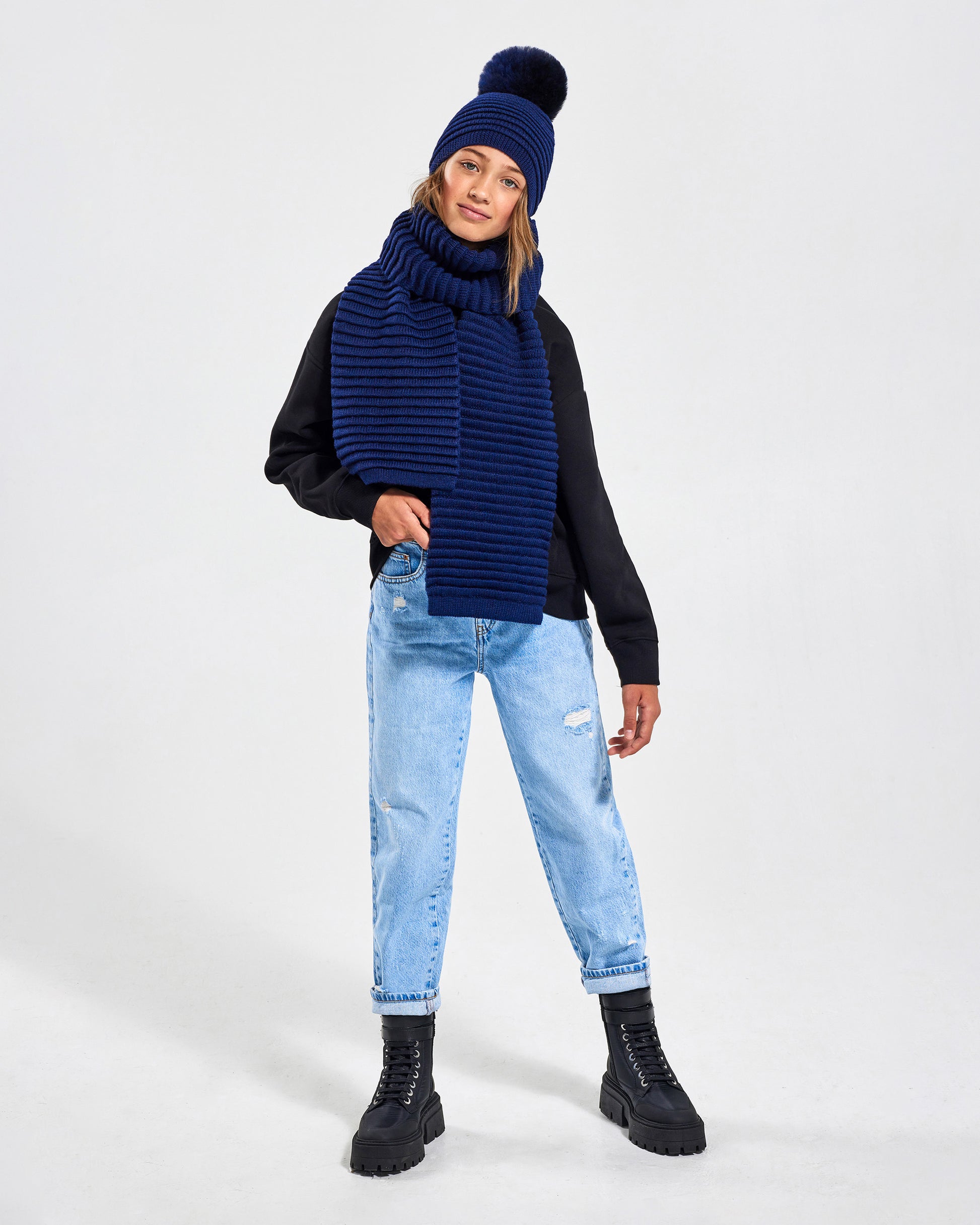 Sentaler Kids Ribbed Navy Hat with Fur Pompon (6-14 Years) in Baby Alpaca yarn. Seen from front on girl model.