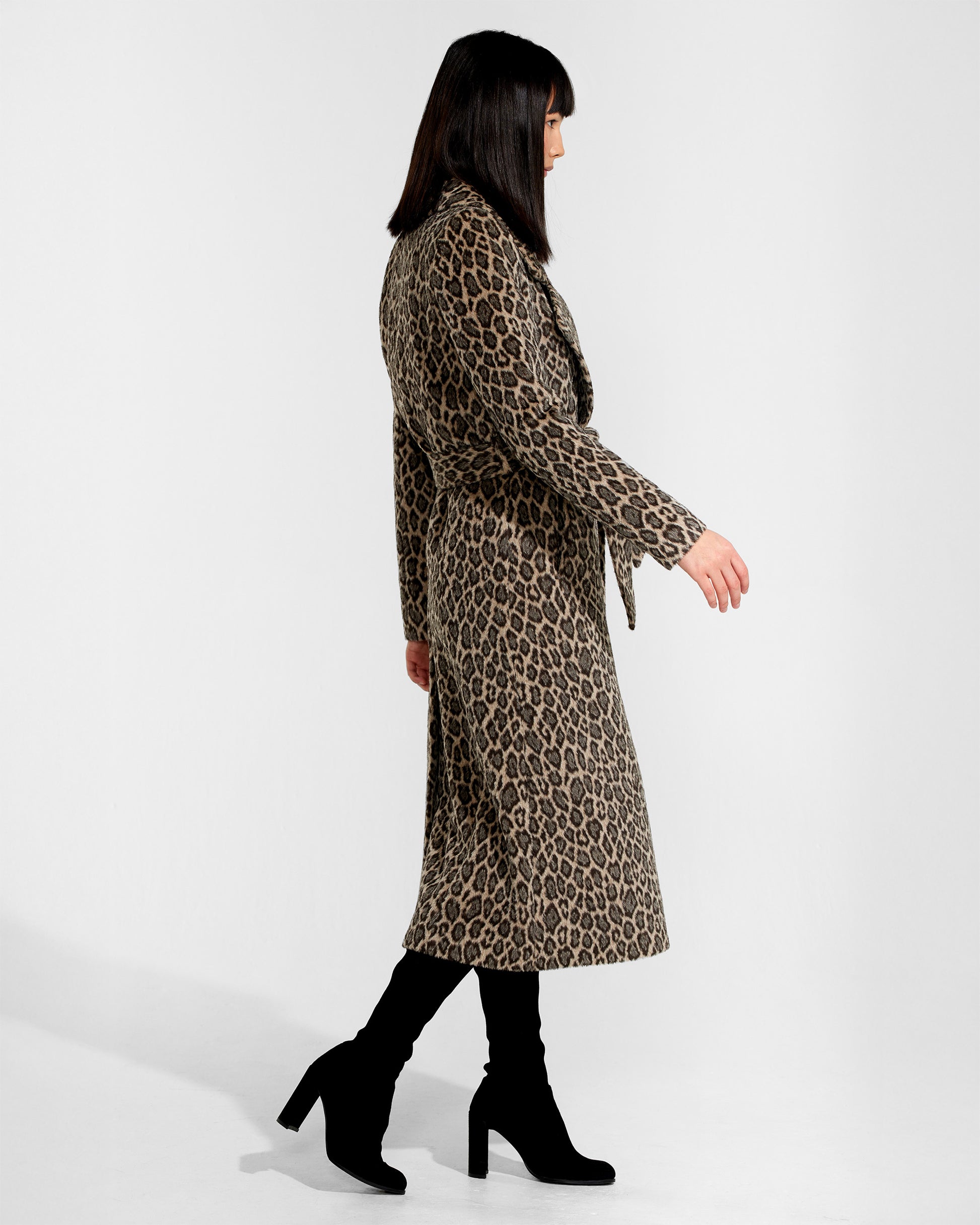 Side view of model wearing a Sentaler leopard wrap coat made of bouclé alpaca wool, with a notched collar, worn belted.