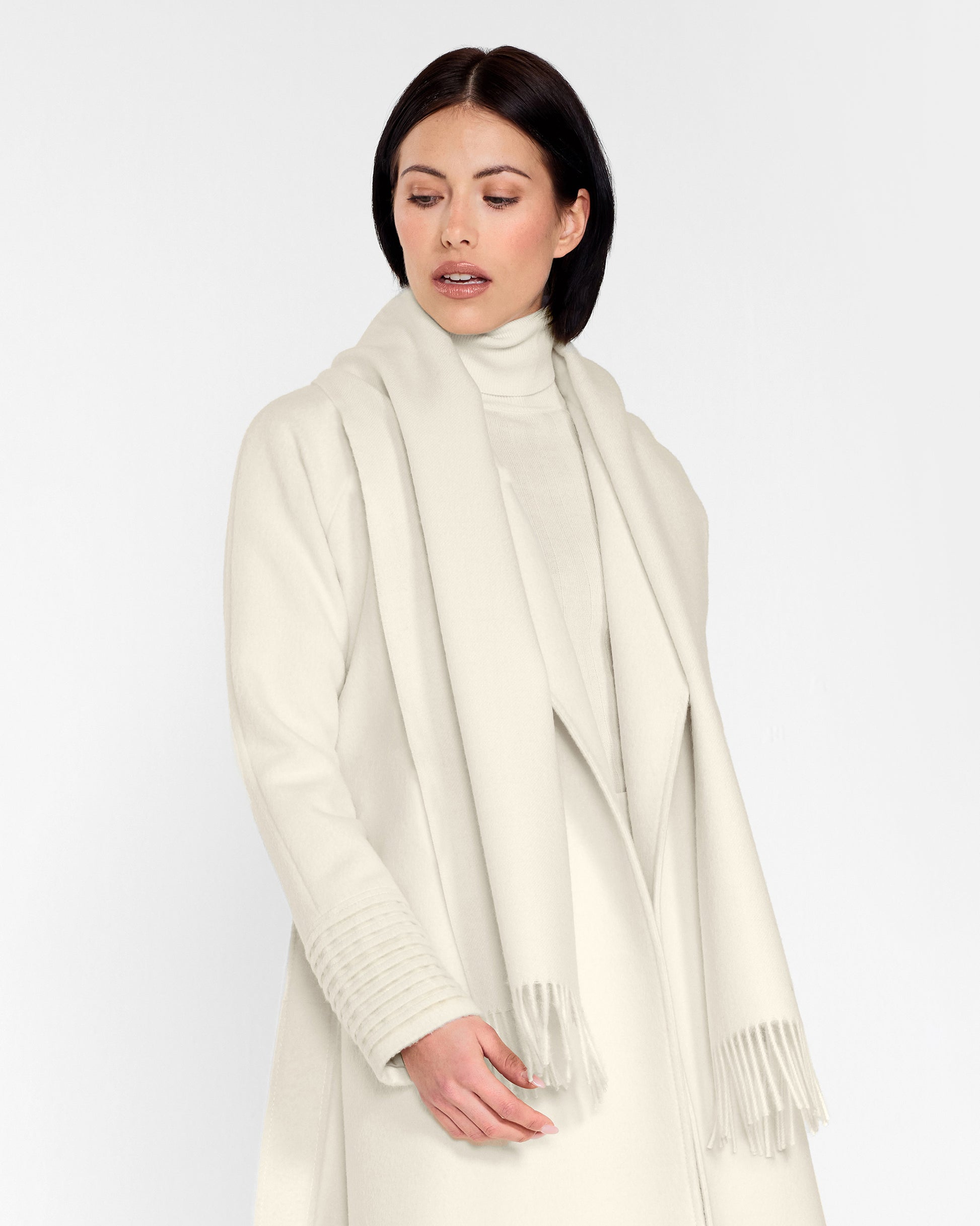 Side close up view of model wearing Sentaler's adult Ivory classic scarf, made of baby alpaca yarn. 