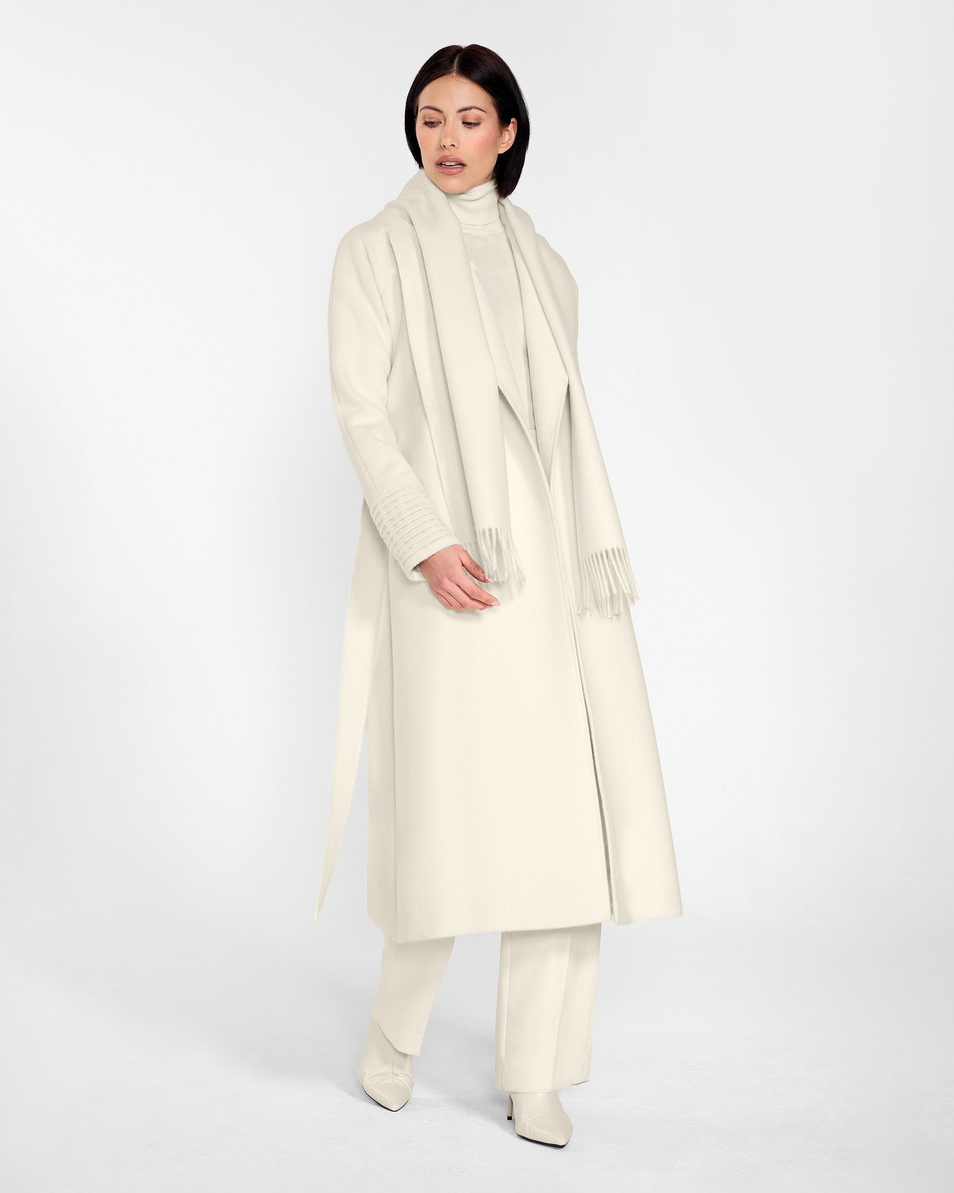 Side view of model wearing Sentaler's adult Ivory classic scarf, made of baby alpaca yarn. 