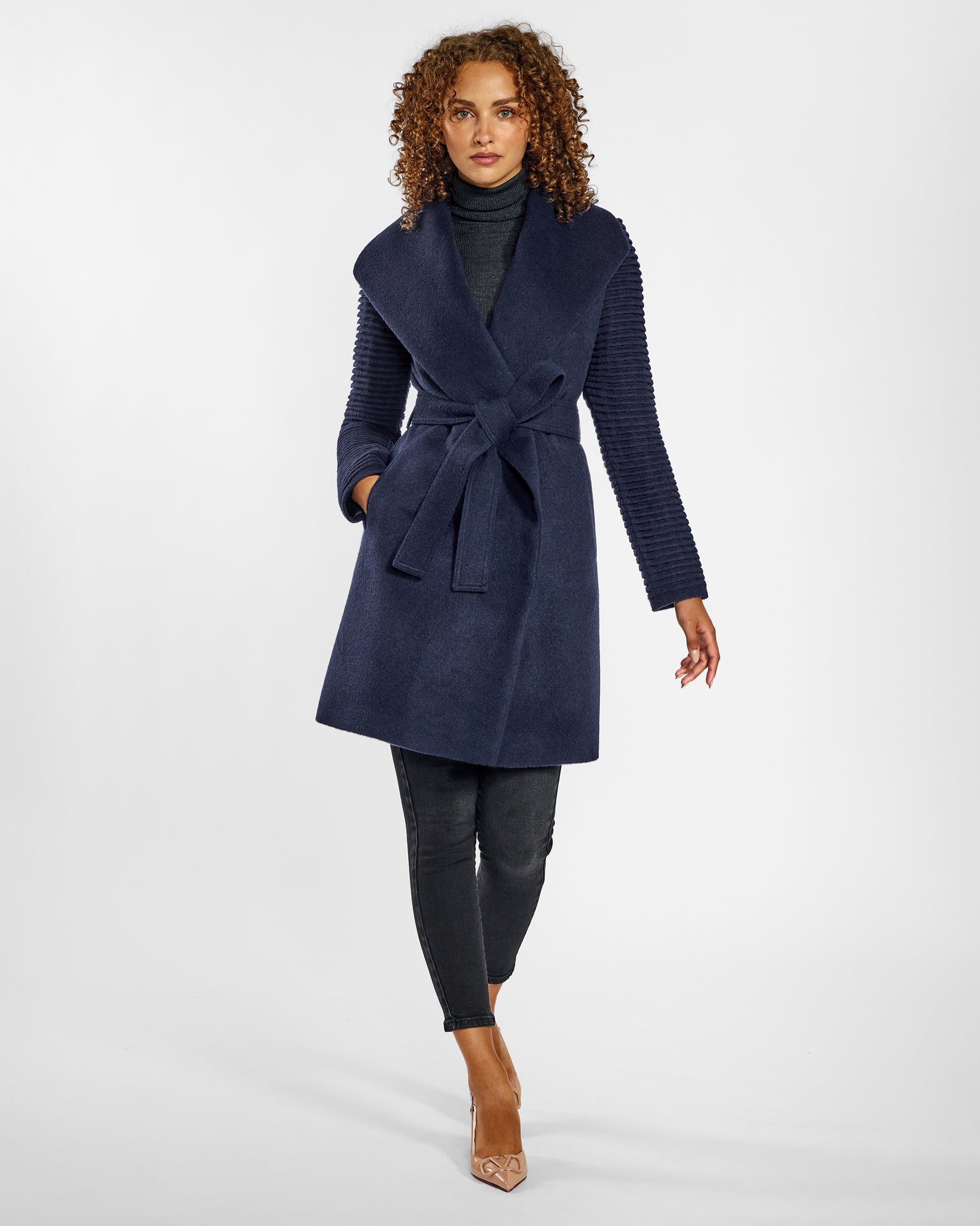 Front view of model wearing a Sentaler mid length deep navy wrap coat made of baby alpaca wool, with ribbed sleeves, worn belted.