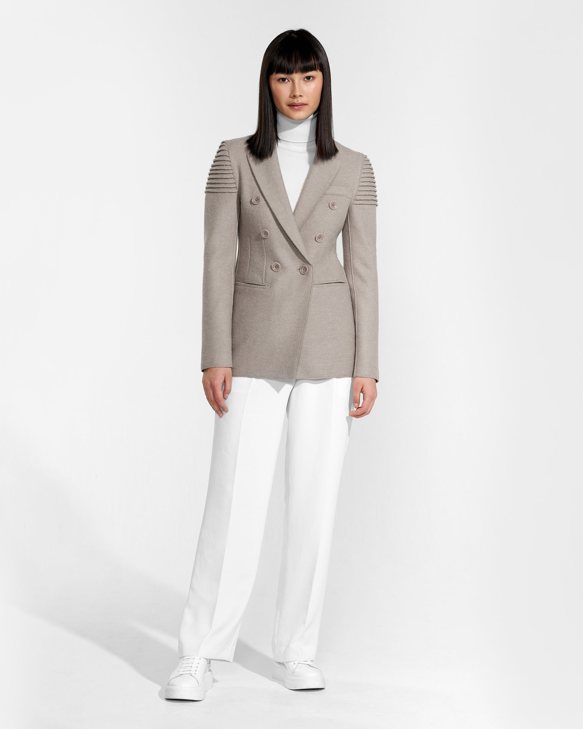 Front view of model wearing a Sentaler double breasted simply taupe blazer made of baby alpaca wool, worn buttoned.