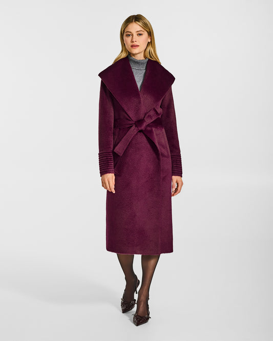 Front view of model wearing a Sentaler long cherry lacquer wrap coat made of suri alpaca wool, with a shawl collar, worn belted.