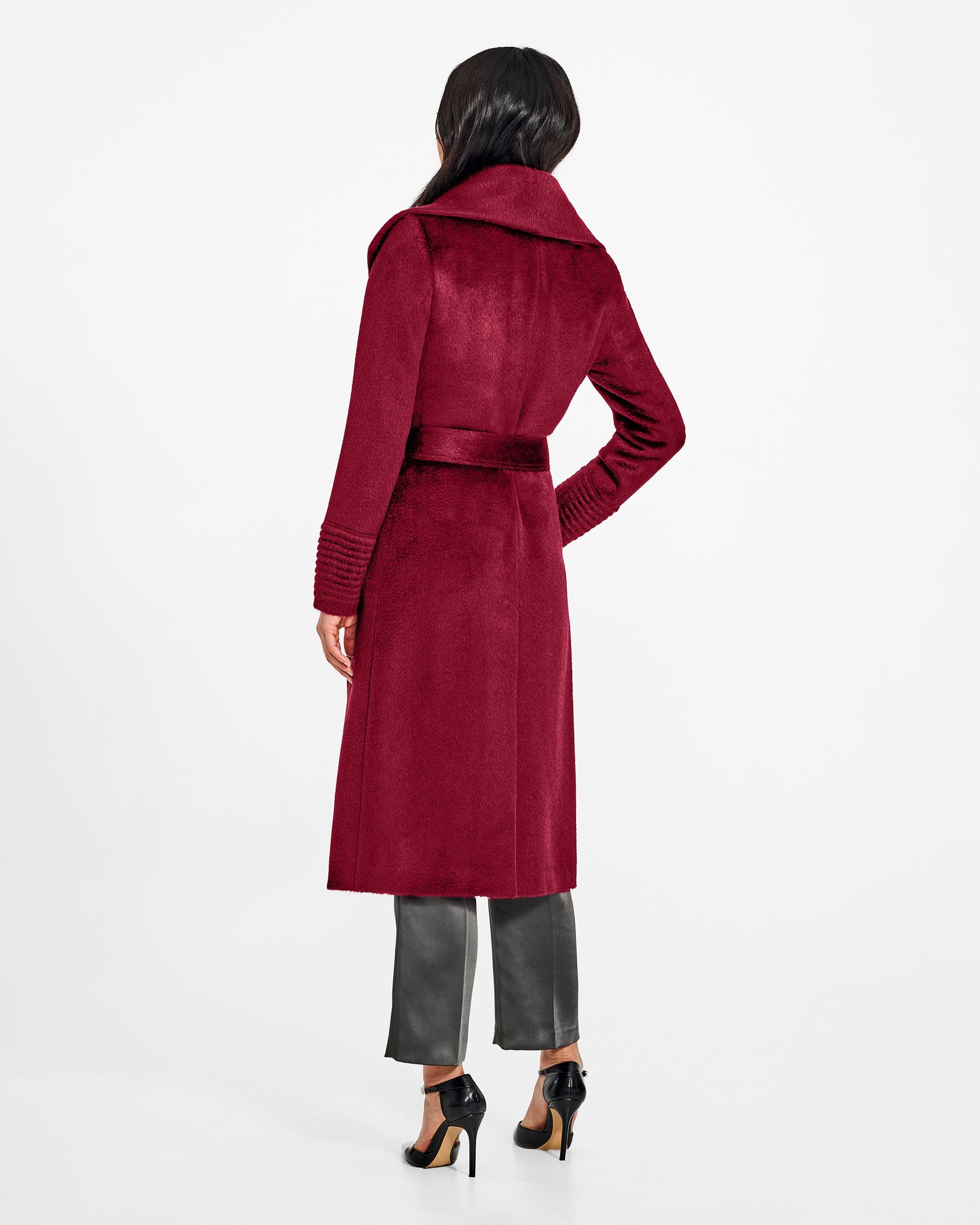 Back view of model wearing a Sentaler long bordeaux wrap coat made of suri alpaca wool, with a shawl collar, worn belted.