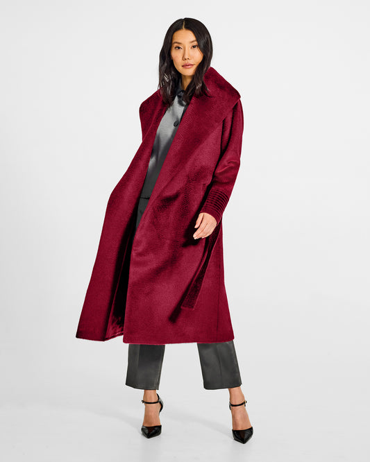 Front view of model wearing a Sentaler long bordeaux wrap coat made of suri alpaca wool, with a shawl collar, worn open.